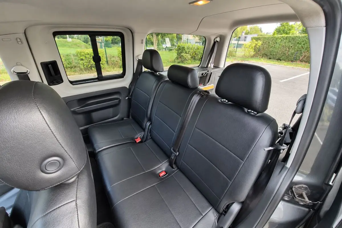 La banquette arrière du taxi JB TRANSPORT : trois places aux sièges noirs, chacune avec sa ceinture de sécurité