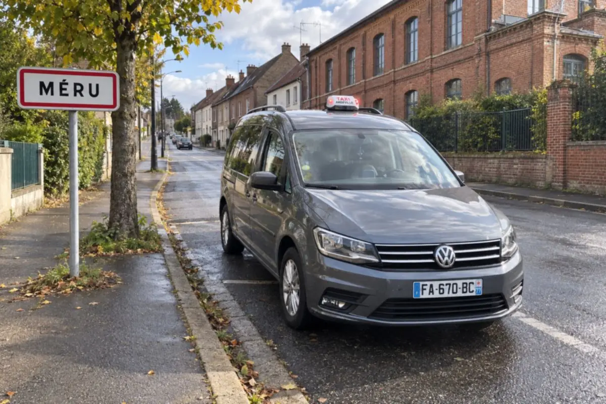 Le taxi JB TRANSPORT garé près du panneau d’entrée de Méru